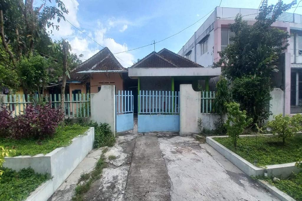 a house with a white fence and a gate at OYO 95055 Homestay Panasan Pak Budi in Kedungtengkong