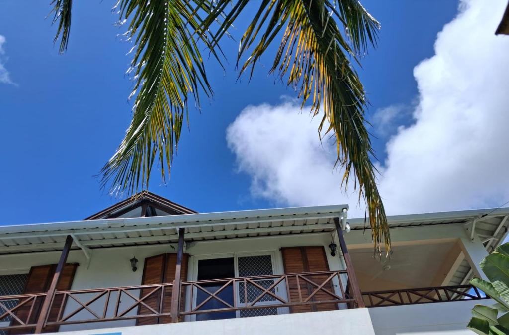 a house with a palm tree in front of it at A few steps from the beach in Pereybere