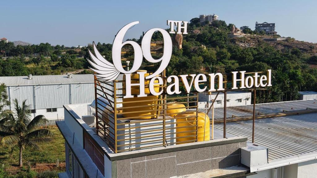 a sign for a heaven hotel on top of a building at 69th Heaven Hotel in Devanhalli