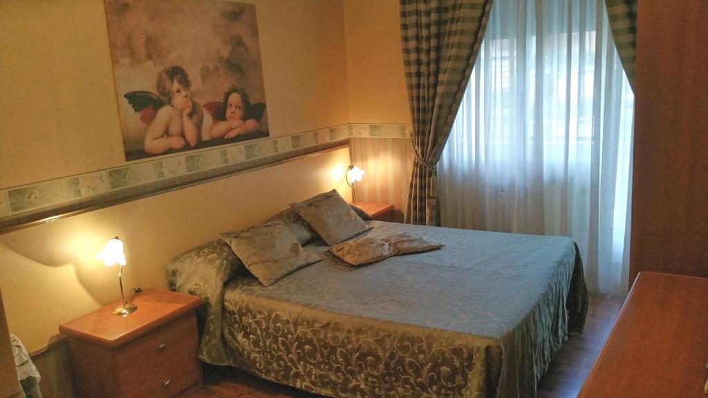 ローマにあるPetite Maisonのベッドルーム1室(ランプ2つ、窓付)