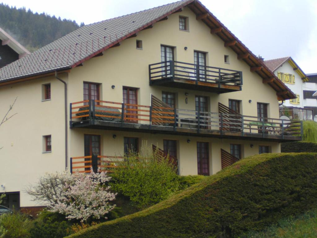 Una gran casa blanca con balcones en una colina en Les 4 Saisons en Gérardmer