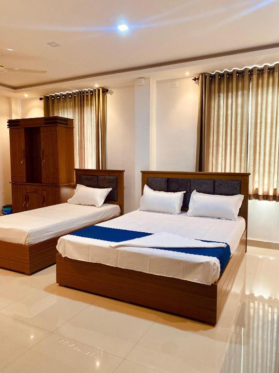 two beds in a hotel room with at Metro Residency in Perintalmanna