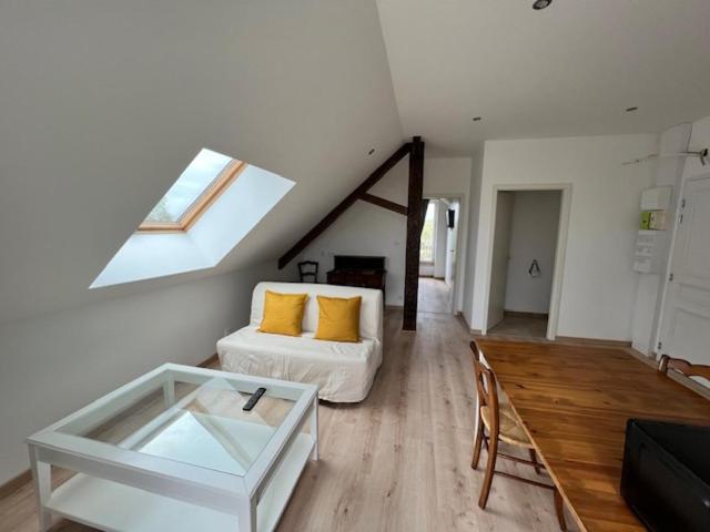 een woonkamer met een witte bank en een raam bij Domaine de Val combe in Dole