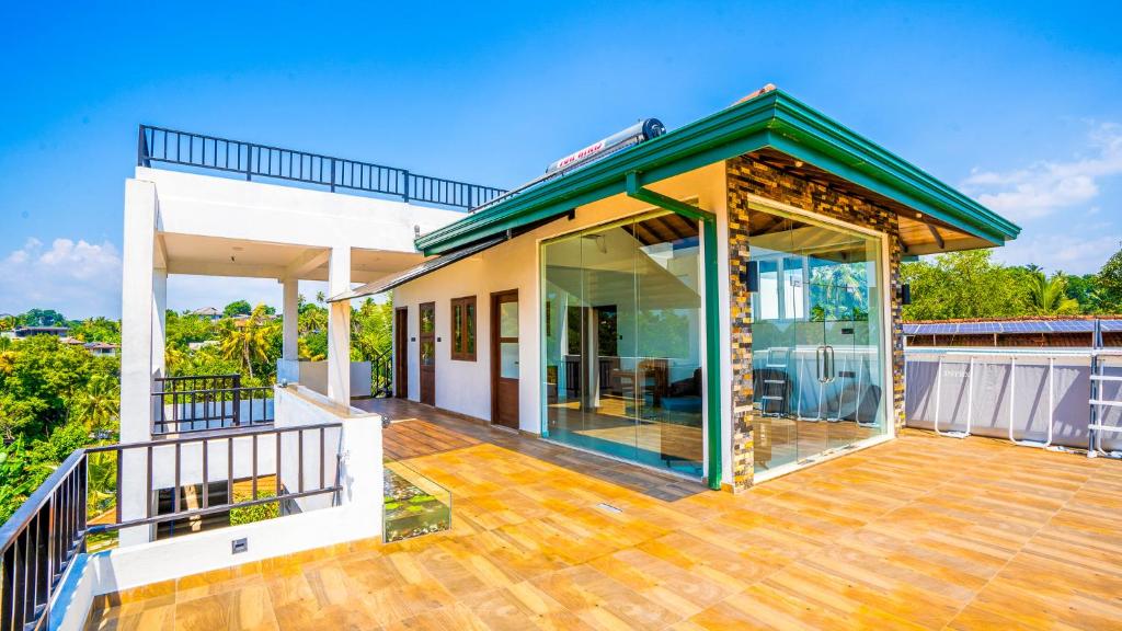 a house with a large deck with glass doors at The Green Homestay - Galle in Galle