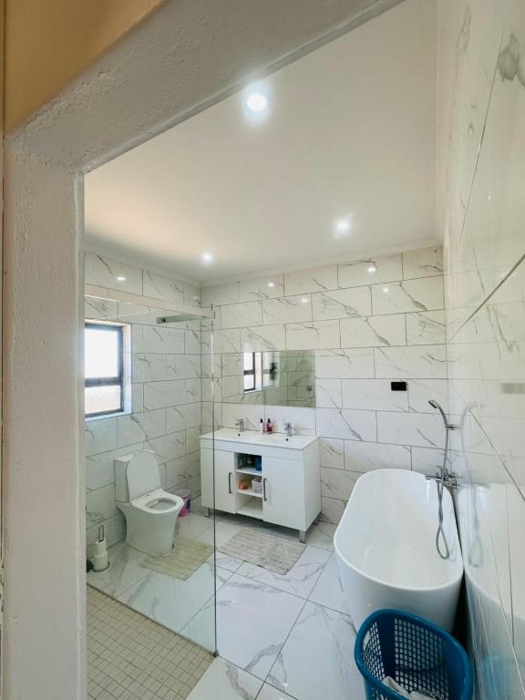 a white bathroom with a sink and a toilet at Private Room behind Out of Africa in Otjiwarongo
