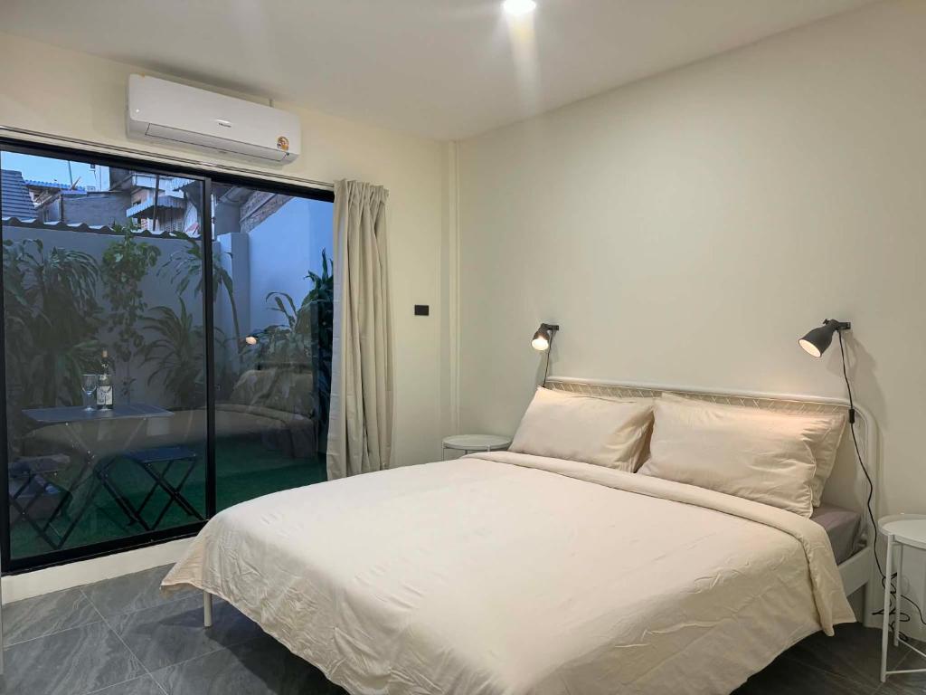 een slaapkamer met een bed en een groot raam bij Scandi Haus near ChinaTown in Bangkok