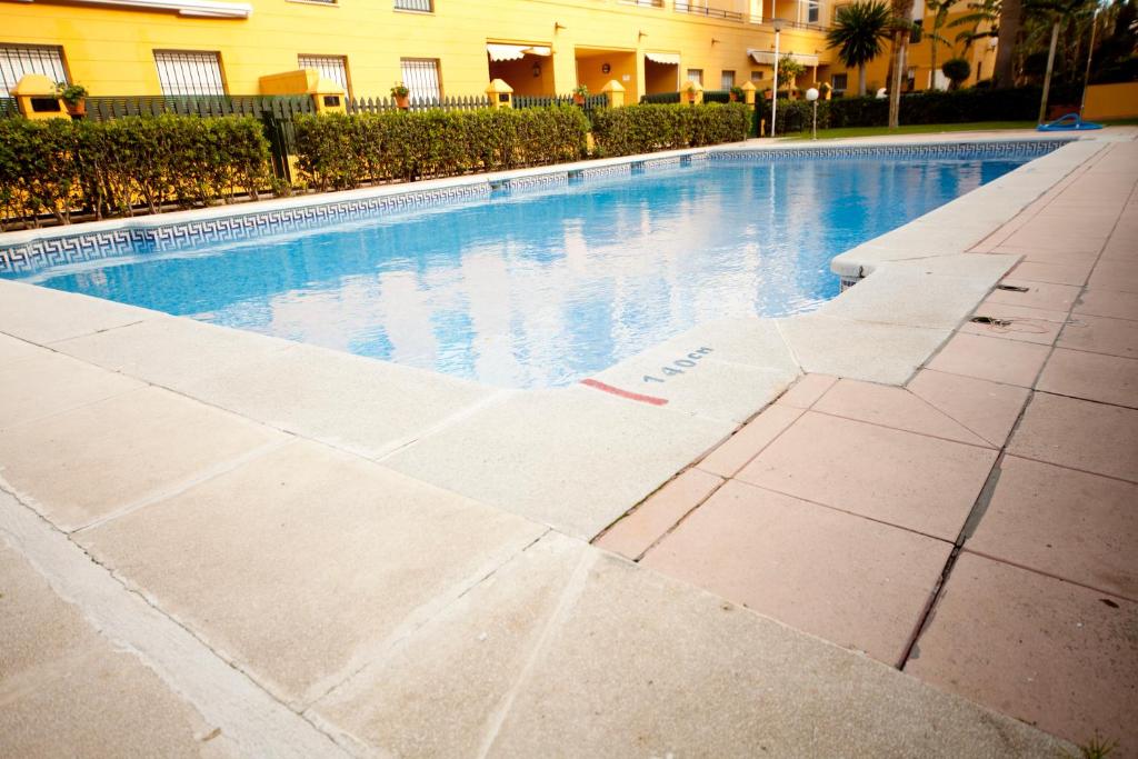 a swimming pool in front of a building at Ático Barrio de los Pescadores in Costa Ballena