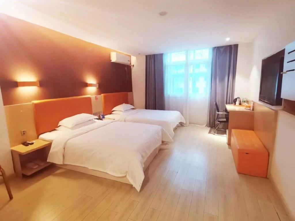 une chambre d'hôtel avec deux lits et un bureau dans l'établissement 7 Days Premium Hotel Ji'an Taihe Gongnongbing Avenue, à Taihe