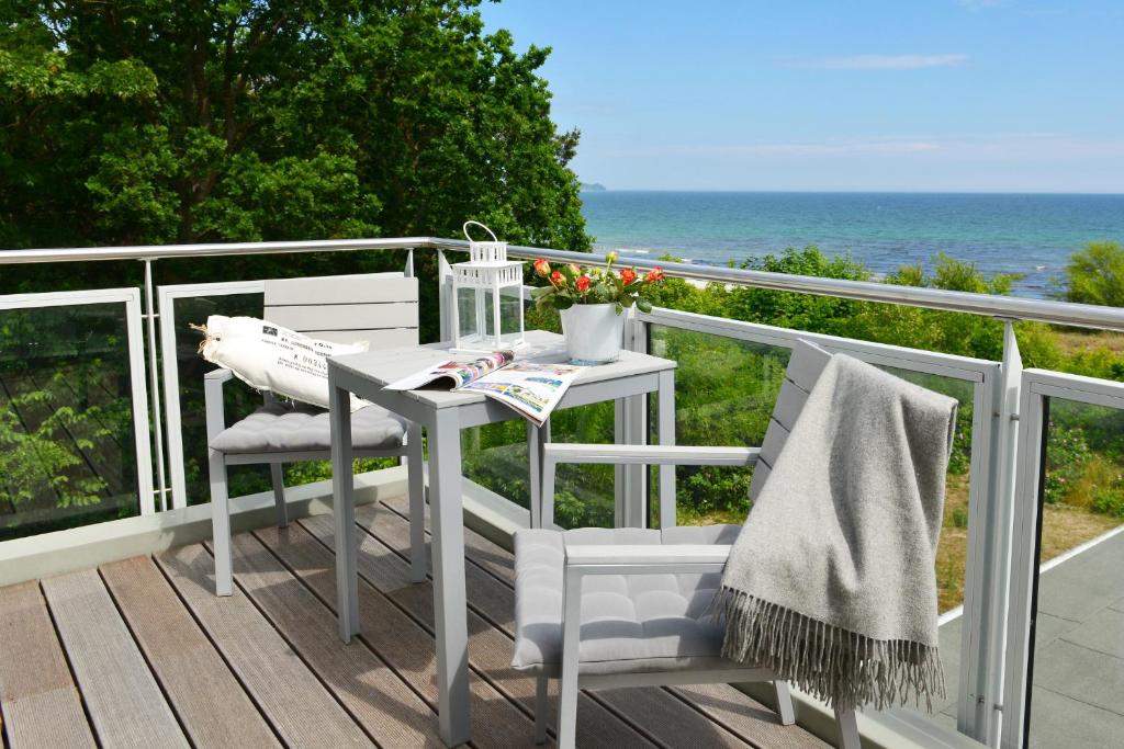 ユリウスルーにあるStrandperleの白いテーブルと椅子、海を望むバルコニー