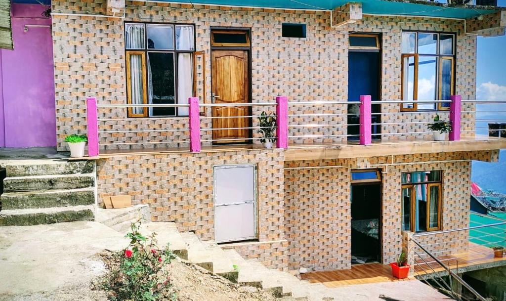 a brick house with pink railings on it at Mukhia's Homestay - Takdah in Darjeeling