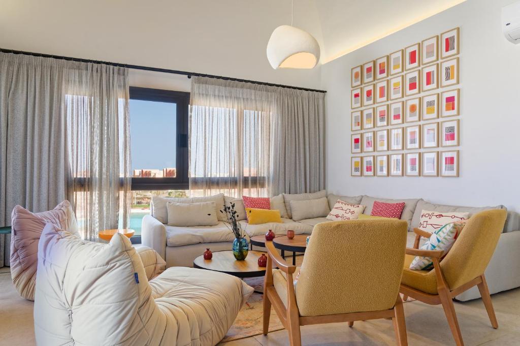 a living room with a white couch and chairs at VESTA - El Gouna Residence in Hurghada
