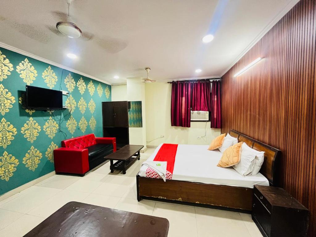 Un dormitorio con una cama y un sofá rojo. en Imperial Residency - Karol Bagh, en Nueva Delhi
