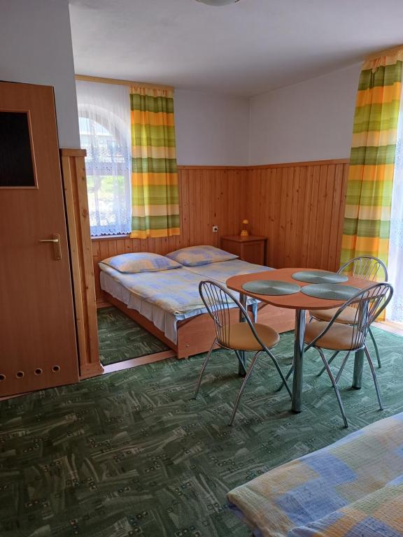 Un dormitorio con una cama y una mesa y sillas. en Pokoje Gościnne Murowanica, en Murzasichle