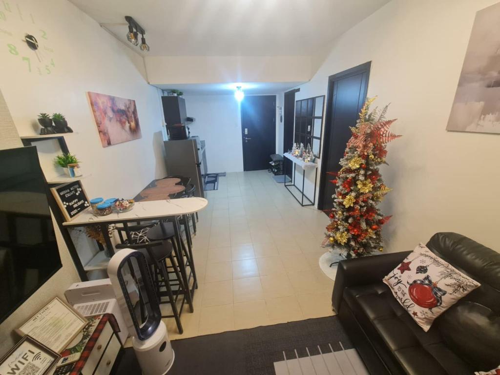 a living room with a couch and a christmas tree at Urban Metro Escape in Pasig City in Manila