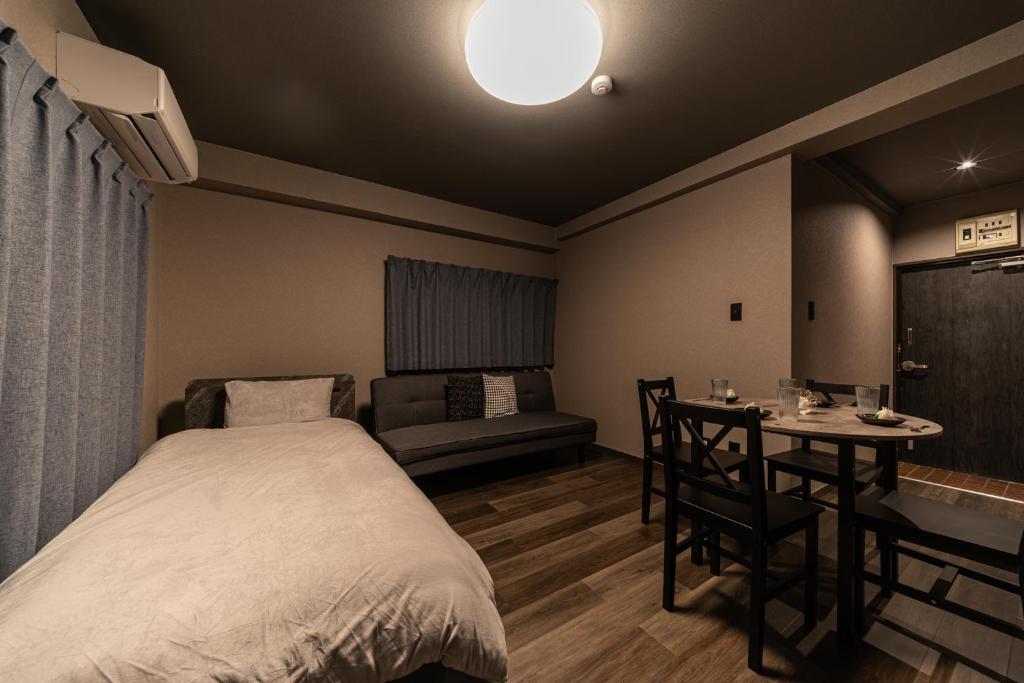 a bedroom with a bed and a table and a couch at おやど紀伊国屋えびす町 in Nagasaki