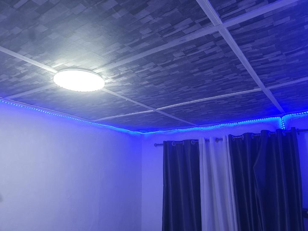 a room with a ceiling with a light and a curtain at SUITE in THE MIDDLE in Kigali