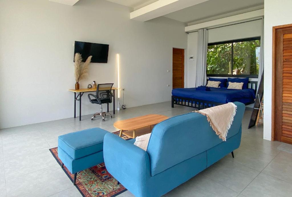 a living room with a blue couch and a table at Kanchaya Residence Apartment in Ko Ma
