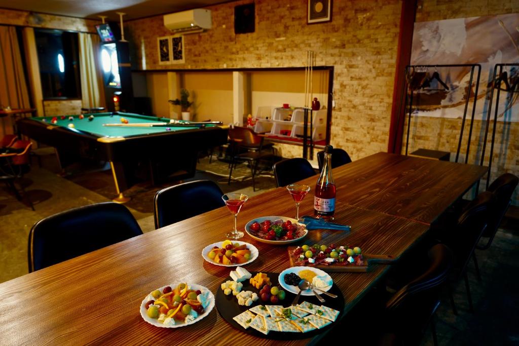 ein Tisch mit Speisen und Getränken und ein Billardtisch in der Unterkunft ザホテル湯沢スターダスト in Yuzawa