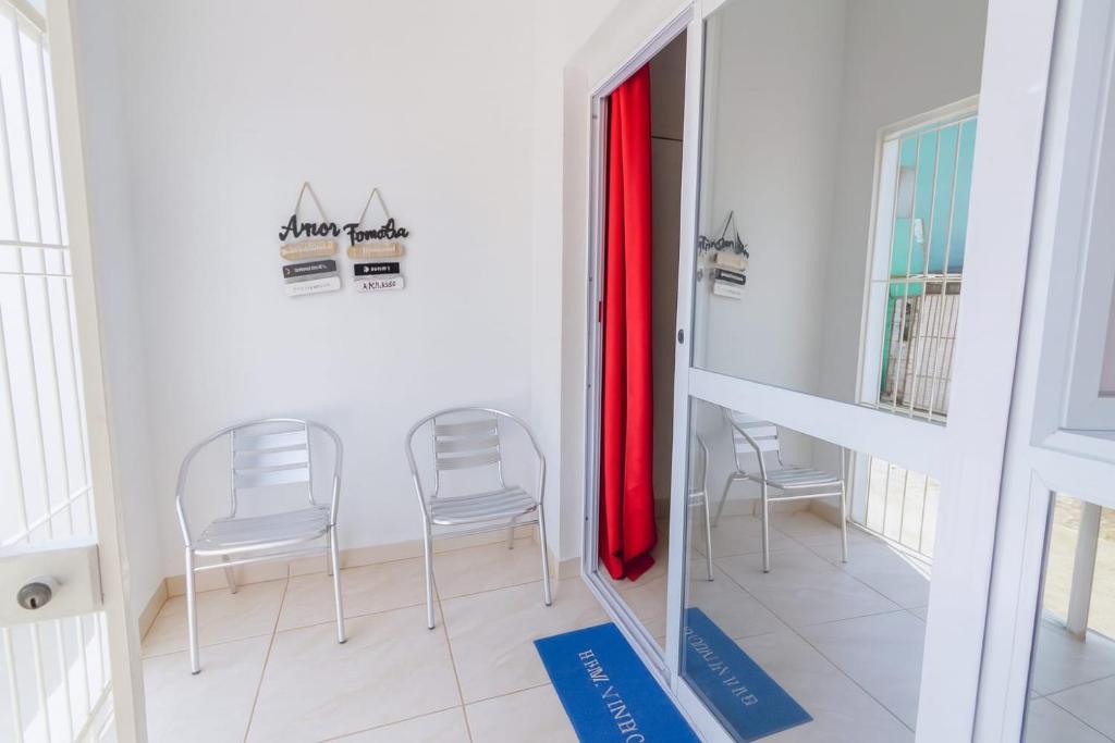 two chairs and a table in a room with a mirror at Doce Lar 58-Casa de Hóspedes in Cabo de Santo Agostinho