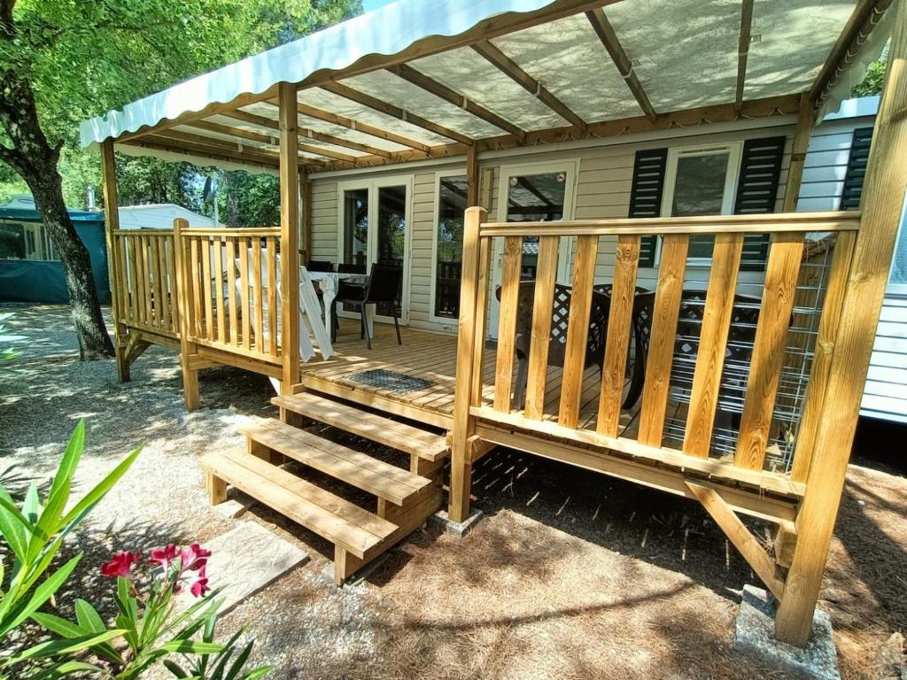 a wooden deck with a pergola on a house at Luxe 6 persoons Chalet camping Leï Suves Cote d'Azur Roquebrune-sur argens in Roquebrune-sur-Argens