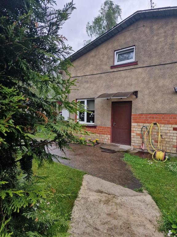a brick house with a red door and a yard at Brīvdienu māja Vecdaugavā in Rīga