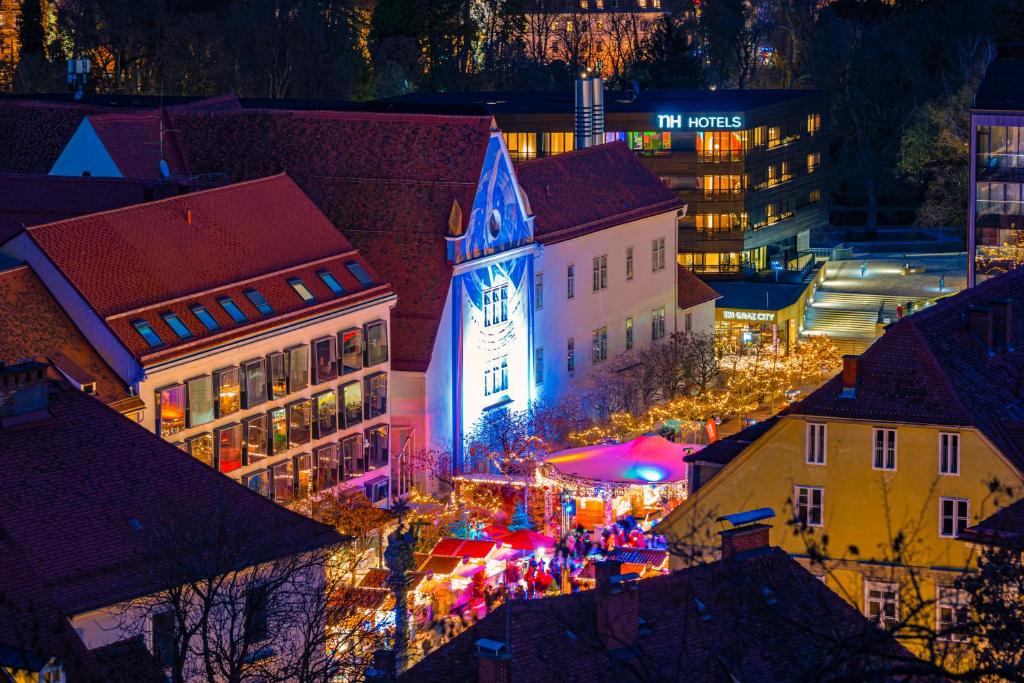 an overhead view of a city at night at NH Graz City in Graz