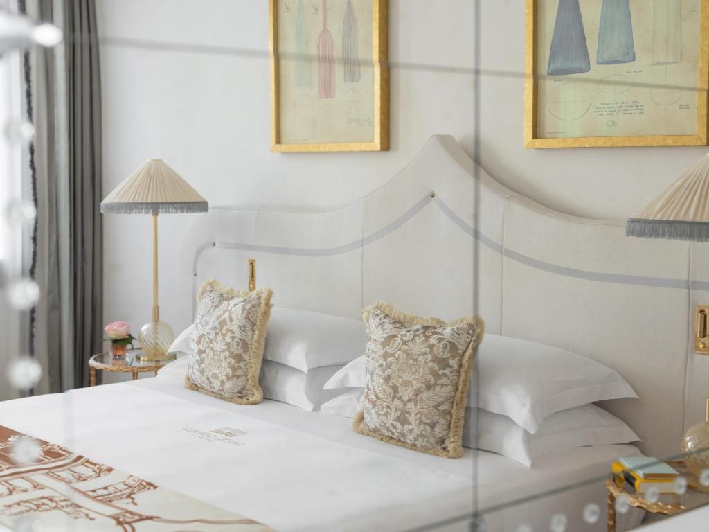 a bedroom with a white bed with two pillows at Gabrielli Luxury Apartments Venezia - Starhotels Collezione in Venice