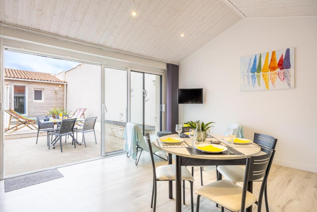 una sala da pranzo con tavolo e sedie di Agréable Maison Sablaise a Les Sables-dʼOlonne