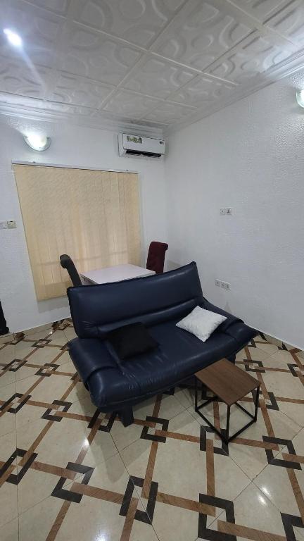 Una sala de estar con un sofá azul y una mesa. en Hometune, en Lagos