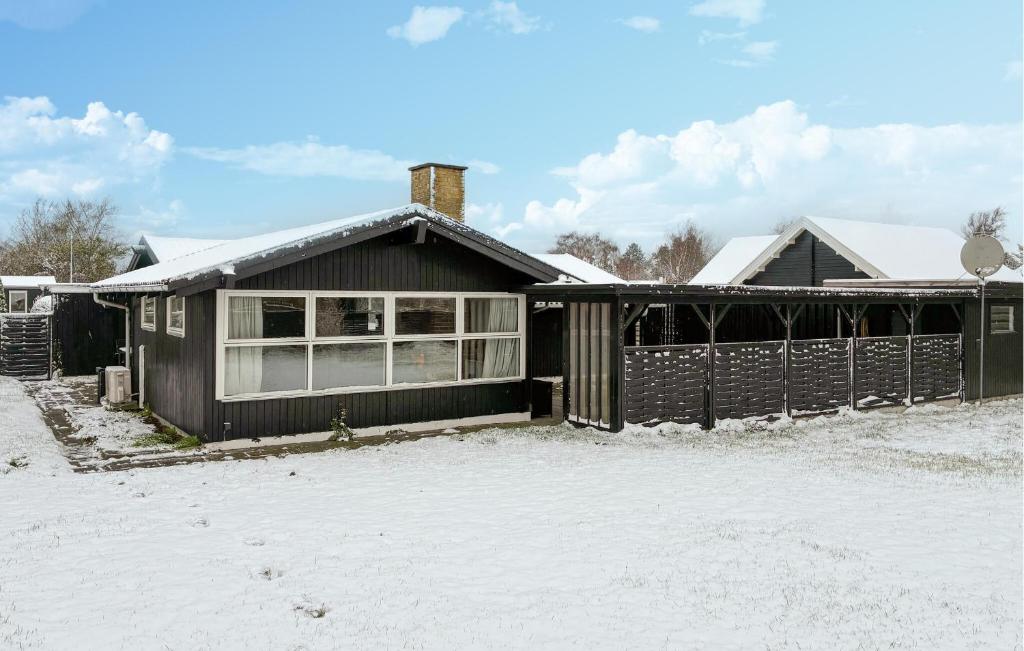 a black house with snow on the ground at 3 Bedroom Cozy Home In Korsør in Tjæreby