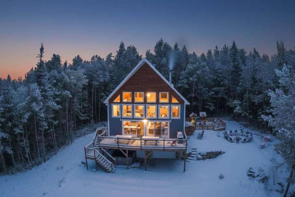 een huis midden in een met sneeuw bedekt bos bij Spa and Mountain - Chalet du Verseau in Mandeville