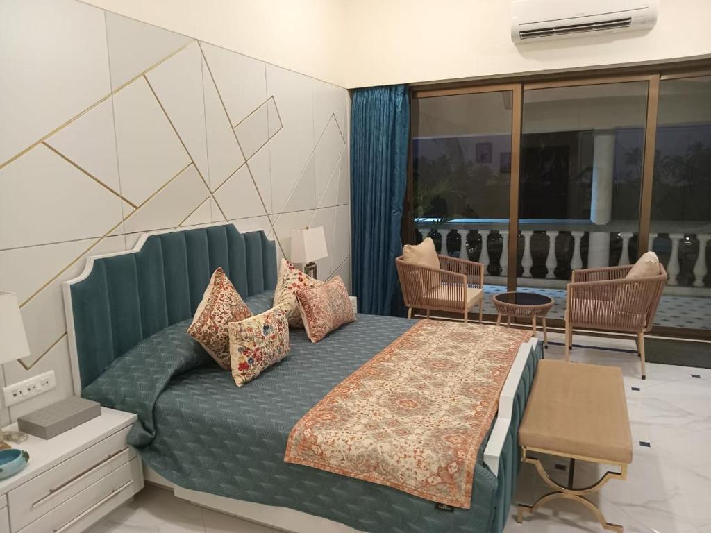 a bedroom with a king sized bed and a balcony at Beach villa South Goa in Arossim-Cansaulim