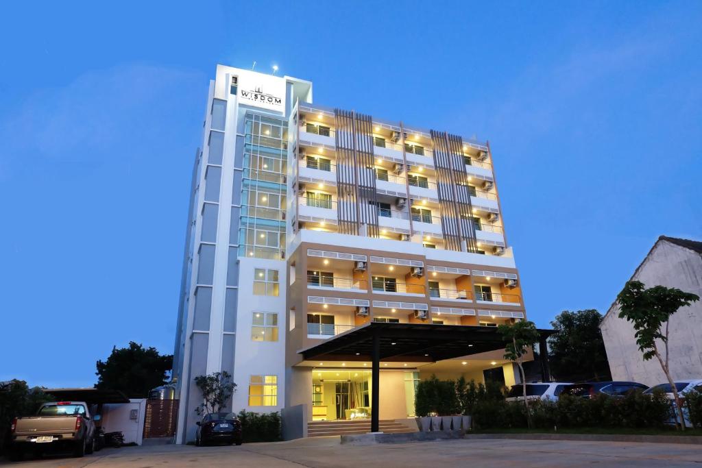 um edifício de hotel com um parque de estacionamento em frente em Wisdom Residence em Hat Yai