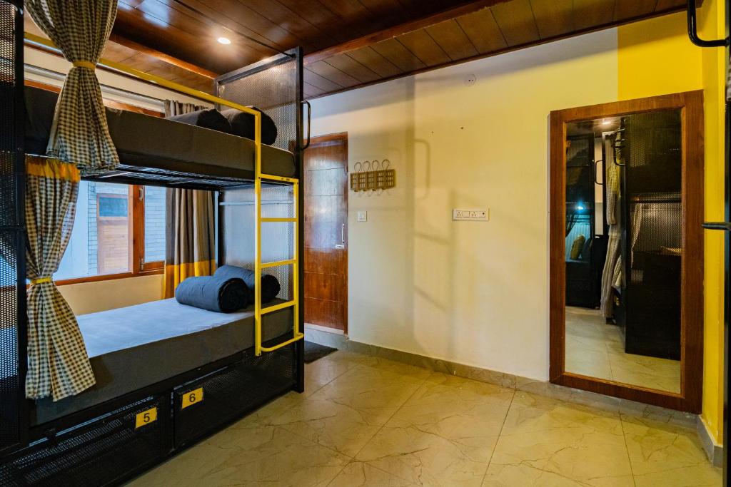 a room with a bunk bed and a mirror at The Hosteller Kasol, Parvati Valley in Kasol