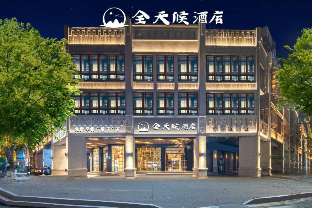 a large building with a sign on top of it at Wenzhou all-day hotel is located in the city center of Wuma Street, convenient to travel, laundry service is provided, WiFi full coverage, free breakfast, coffee, afternoon tea, food and tourist attraction recommendations in Wenzhou