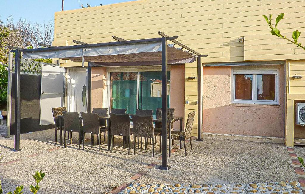 a dining table and chairs under a canopy in front of a house at Villa La Playa in Saint-Raphaël