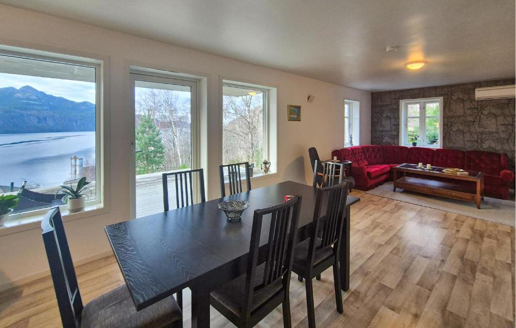 Una sala de estar con una mesa de comedor y un sofá. en Amazing Apartment In Forsand With House Sea View, en Helle