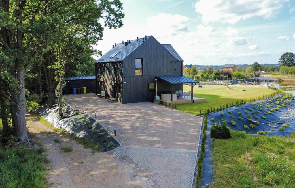 a black barn with a large yard next to a river at Cozy Home In Sianowo With Wifi in Sianowo