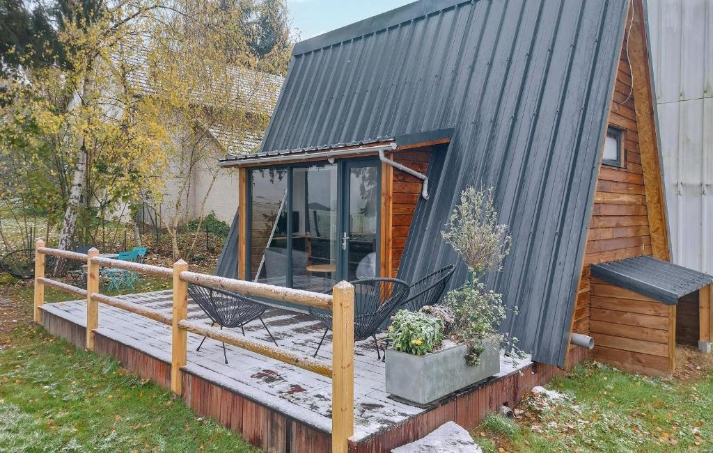 una casa pequeña con techo negro y terraza en Nice Home In Herry With Heated Swimming Pool, en Herry