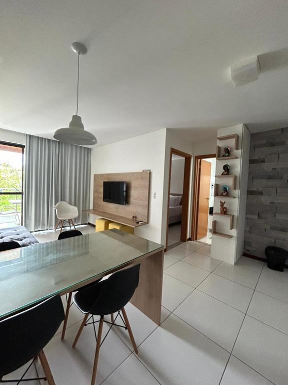 a kitchen and living room with a table and chairs at Flat Resort ILOA in Barra de São Miguel