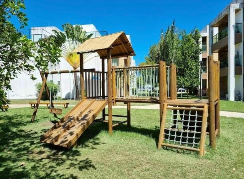 a wooden swing set in a park at Flat Resort ILOA in Barra de São Miguel