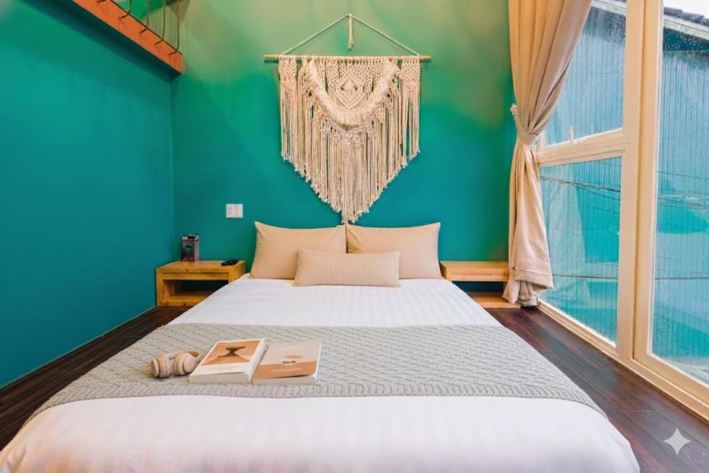 Rose Hill Villa Dalat في دالات: غرفة نوم بسرير كبير وبجدار اخضر