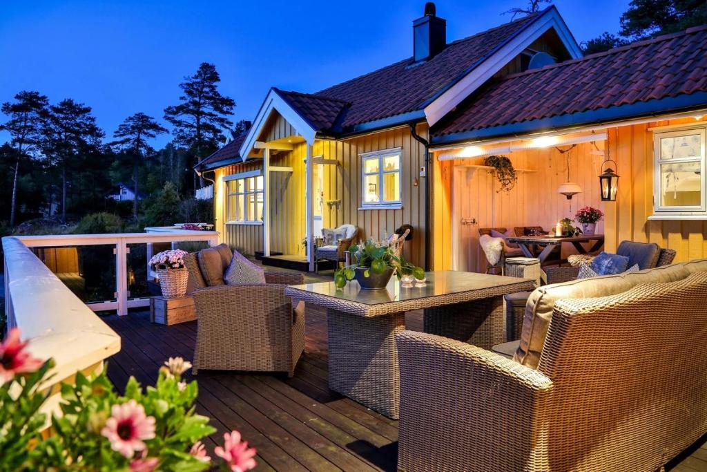 a deck with wicker furniture and a house at Furuheimen - cabin by the sea in Skjeberg in Skjeberg