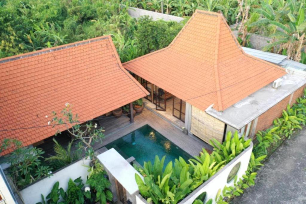 een luchtfoto van een huis met een zwembad bij Heliconia Joglo House in Sempidi