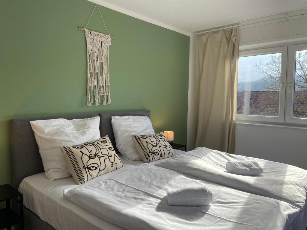 una camera da letto con un letto bianco con cuscini e una finestra di Stilvolles Apartment,Familien und Gruppen,3SZ,Legoland,Ulmer Münster,bis6P a Blaustein