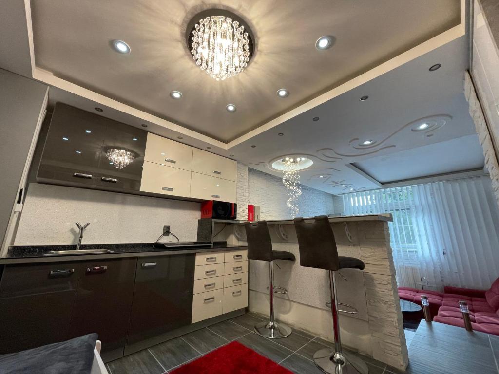 cocina con fregadero y 2 taburetes en Lipno Pearl Terasa, en Lipno nad Vltavou