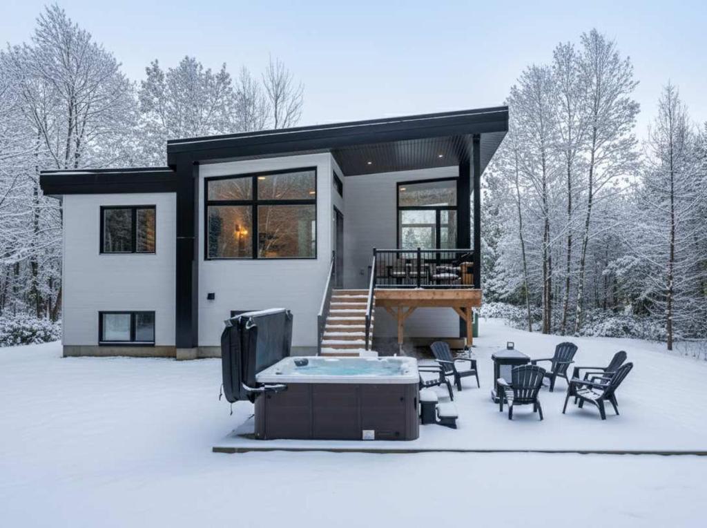 una casa nella neve con tavoli e sedie di Spa & Adventure - Chalet Valikas a Weedon-Centre