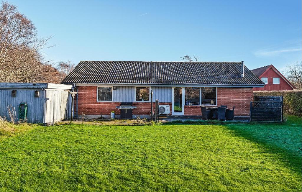 a red brick house with a grass yard at 3 Bedroom Beautiful Home In Hjørring in Mejeriby