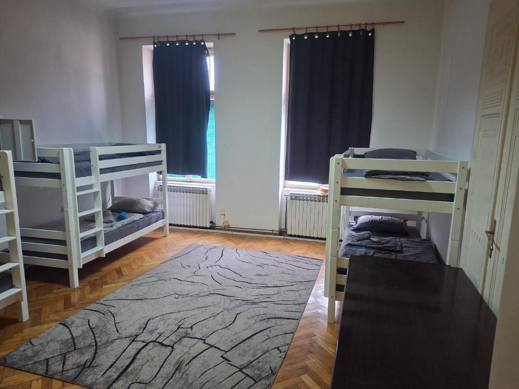 een kamer met 2 stapelbedden en een tapijt bij Hostel Latin Bridge in Sarajevo
