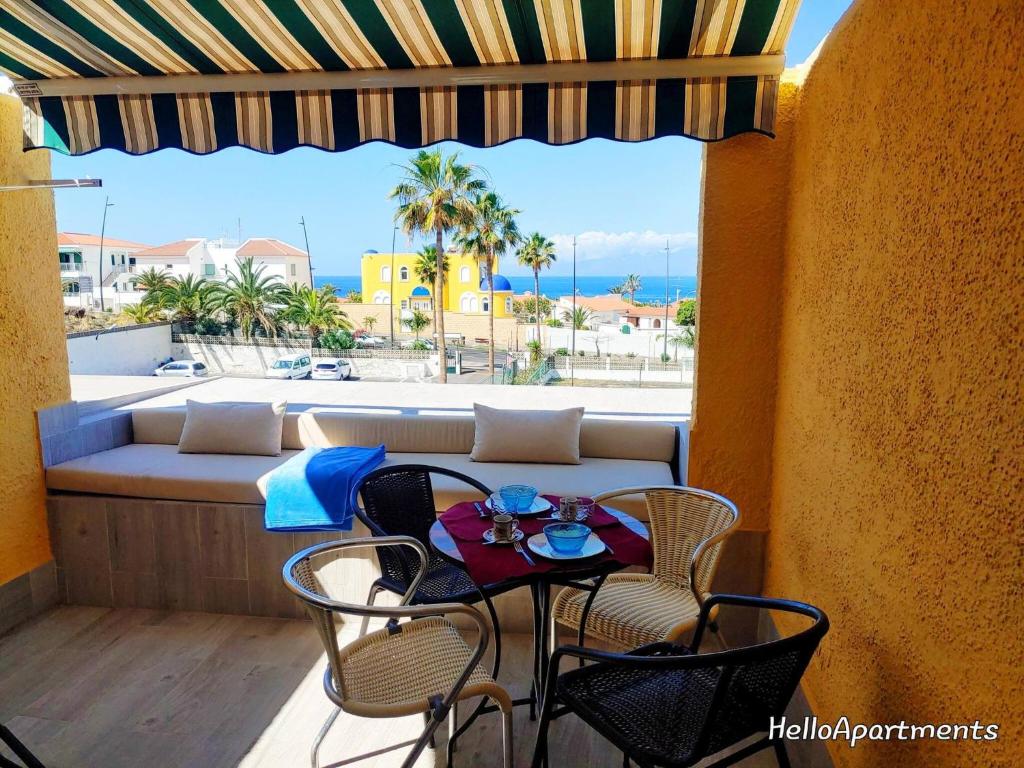 Un patio con una mesa y sillas en un balcón. en Ocean View Playa la Arena by HelloApartments, en Puerto de Santiago